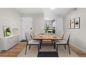 A bright and modern dining room is furnished with a wooden table and six neutral-colored chairs at 3656 S Depew St # 102, Denver, CO 80235