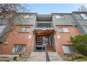 A charming exterior entrance with wooden stairs and a balcony above a unit's front door at 3656 S Depew St # 102, Denver, CO 80235