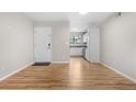 Open-concept living room with wood floors, a bright white front door, and easy access to the kitchen at 3656 S Depew St # 102, Denver, CO 80235