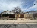Backyard with dilapidated fence, overgrown weeds, and distant houses at 1021 Downing Way, Denver, CO 80229