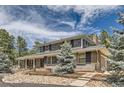 Charming two-story home showcasing brick and gray shingle siding, complemented by a spacious, welcoming front porch at 12454 Antelope Trl, Parker, CO 80138