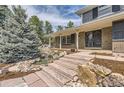 Inviting front entrance with stone steps, lush landscaping, and a tranquil water feature, enhancing curb appeal at 12454 Antelope Trl, Parker, CO 80138