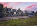 Charming brick home featuring a covered porch, lush landscaping, and a detached garage in the background at 12454 Antelope Trl, Parker, CO 80138