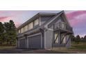 Three-car garage with living quarters above, showcasing gray siding and a small balcony at 12454 Antelope Trl, Parker, CO 80138