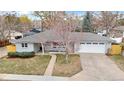 Aerial view of a charming single-story home with a well-maintained lawn and a large driveway at 2455 E Yale Ave, Denver, CO 80210