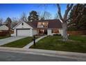 Charming single-story home boasts a lush front lawn, a driveway, a garage, and a second story balcony at 4970 S Chester St, Greenwood Village, CO 80111