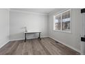 Bright, empty bedroom showcasing modern floors, large window, and white trim at 6220 Waterman Way, Frederick, CO 80516