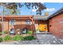 Inviting brick home with covered patio seating area and well-manicured landscaping, great for relaxing at 421 Iola St, Aurora, CO 80010