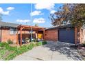 Charming brick home with covered patio, lush landscaping, and attached garage, perfect curb appeal at 421 Iola St, Aurora, CO 80010
