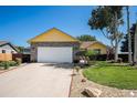 Well-maintained home with a long driveway, attached garage, and beautifully landscaped front yard at 1030 S Fulton Ave, Fort Lupton, CO 80621