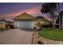 Well-maintained home with a long driveway, attached garage, and beautifully landscaped front yard at sunset at 1030 S Fulton Ave, Fort Lupton, CO 80621