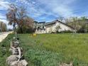 Exterior shot of a grassy lot for sale, sunny weather, and surrounding buildings at 5375 W 60Th Ave, Arvada, CO 80003