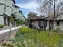 Exterior view of new row houses next to a yard with wildflowers at 5375 W 60Th Ave, Arvada, CO 80003