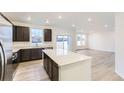 Open-concept kitchen featuring a center island, stainless appliances, and backyard views at 11030 Snowdon St, Parker, CO 80134