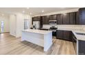 Modern kitchen with dark cabinets, stainless steel appliances, quartz countertops, and large island at 11030 Snowdon St, Parker, CO 80134