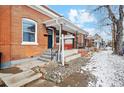 Beautiful red brick house featuring a covered porch and steps to the front door at 1853 W 41St Ave, Denver, CO 80211