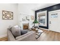 Cozy living room featuring a decorative fireplace and a large window at 1853 W 41St Ave, Denver, CO 80211