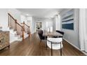 Open concept dining area with hardwood floors and staircase in view at 1027 Koss St, Erie, CO 80516