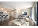 Open-concept living room with wood floors and access to kitchen and sliding glass door to balcony at 50 S Boulder Cir # 5022, Boulder, CO 80303