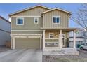 Charming two-story home with green siding, a covered front porch, and an attached two car garage at 3549 Swabuck Pl, Castle Rock, CO 80109