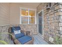 Inviting entryway with stone wall, wicker chair, and small side table at 12910 W Burgundy Dr, Littleton, CO 80127