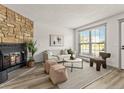 Inviting living room features a stone fireplace, wood floors, and stylish furnishings at 19726 Applewood Ct, Parker, CO 80138