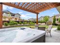 Relaxing backyard oasis featuring a hot tub under a wooden pergola, perfect for outdoor gatherings at 17880 W 94Th Dr, Arvada, CO 80007