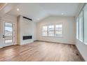 Spacious living room with hardwood floors, fireplace, and large windows at 1885 Hickory Ave, Erie, CO 80516