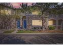 Charming townhome featuring a stone facade, blue door, covered balcony, and well-maintained landscaping at 4222 S Blackhawk Cir # 6G, Aurora, CO 80014