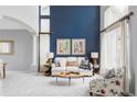 Elegant living room featuring a soaring ceiling, a stylish sofa, and beautiful decor at 7700 Bison Ct, Littleton, CO 80125
