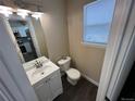 Cozy half bath with a stylish vanity, toilet, and good natural lighting at 12036 Monaco St, Brighton, CO 80602
