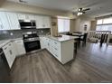Modern kitchen featuring white cabinets, granite countertops, and stainless steel appliances at 12036 Monaco St, Brighton, CO 80602