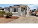 Inviting single-story home featuring light-grey siding, and a cozy entryway leading to the front door at 1040 Florence St, Aurora, CO 80010