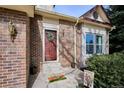 Inviting entryway with a brick facade, a wreath-adorned front door, and a welcoming doormat at 5733 S Killarney Way, Centennial, CO 80015