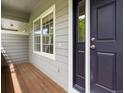Covered porch featuring wood decking and a modern navy blue front door at 19246 E Carolina Pl # 102, Aurora, CO 80017