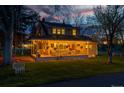 Charming two-story home featuring a welcoming porch with string lights and a swing, set against a beautiful sunset backdrop at 7835 Valley View St, Louviers, CO 80131