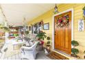 Inviting front porch decorated with cozy seating, colorful plants, and a welcoming floral wreath at 7835 Valley View St, Louviers, CO 80131