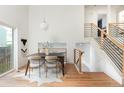 Bright dining room featuring modern table and chairs next to wooden stair case with horizontal bars at 11586 Chase Way, Westminster, CO 80020