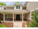 Inviting front entrance with a covered porch, swing, stone walkway, and well-manicured landscaping at 2 University Ln, Greenwood Village, CO 80121