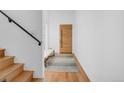 Bright entryway featuring hardwood floors, a sleek staircase, and a modern front door at 2501 Vrain St, Denver, CO 80212