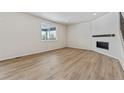 Spacious living room with hardwood floors and a corner fireplace at 3242 Boral Owl Dr, Brighton, CO 80601