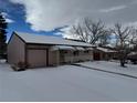 Ranch style home with attached garage and snow-covered front yard at 1851 S Perry Way, Denver, CO 80219