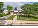 Charming ranch home with a landscaped yard and attached garage at 1851 S Perry Way, Denver, CO 80219