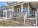 Close-up of the home's front porch with brick supports and gray siding at 16364 Flintlock Ct, Parker, CO 80134