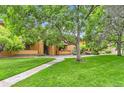 Beautiful condo complex with lush green lawn and mature trees offering a serene living environment at 3315 S Ammons St # 103, Lakewood, CO 80227