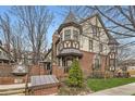 Beautiful Tudor-style home features a brick facade, manicured lawn, mature trees and lovely architectural details at 76 S Garfield St, Denver, CO 80209