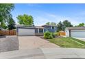 A two-story gray home with solar panels and a well-maintained lawn on a clear day at 9275 W Euclid Ave, Littleton, CO 80123