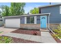 Close-up of a gray home featuring a white garage door and a striking blue front door at 9275 W Euclid Ave, Littleton, CO 80123