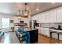 Modern kitchen with a large island, granite countertops, stainless steel appliances, and stylish pendant lighting at 8204 S Vandriver Way, Aurora, CO 80016