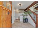 Inviting entryway with tile floors, wood door, staircase, and modern decor at 1549 Hillside Cir, Sedalia, CO 80135